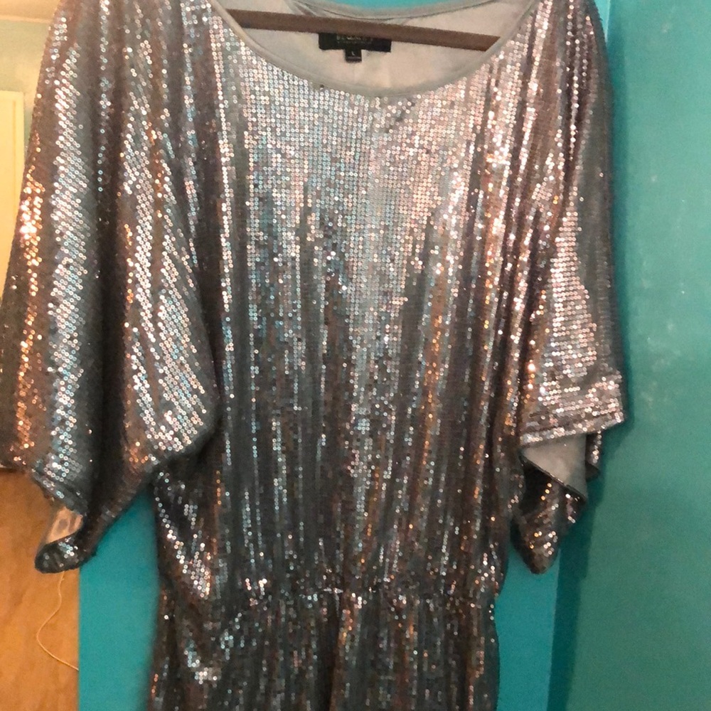 Silver sequins top. Can be worn as a dress if you dare. Has never been worn